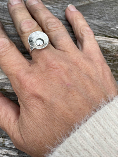 Silver ring in shape of lily pad being worn