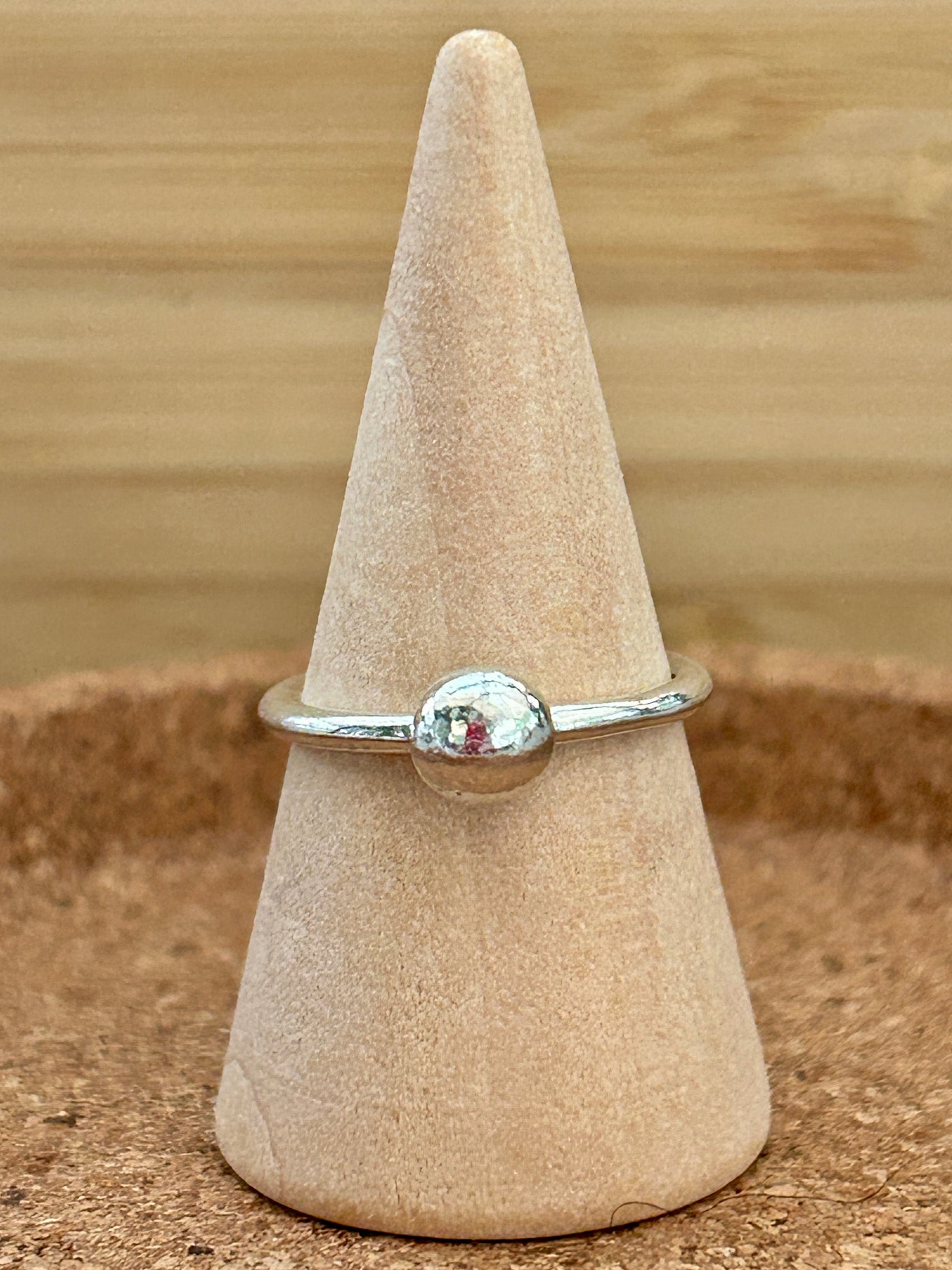 Silver bauble ring shown on a wooden cone