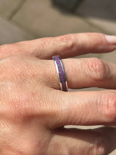 Close-up of a hand wearing a silver opal inlay ring with a sleepy lavender colour opal