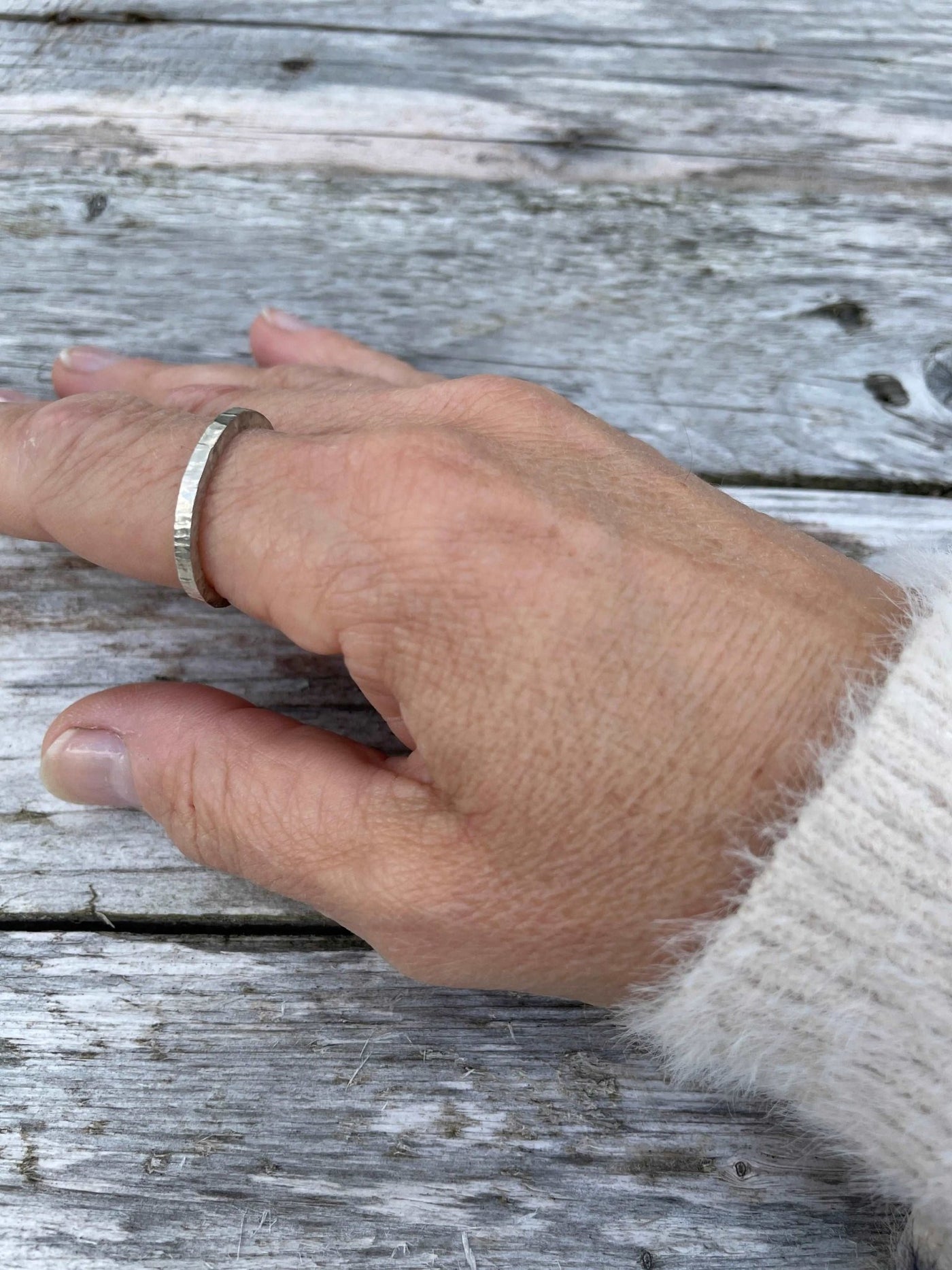 rounded silver stacking band shown on a hand