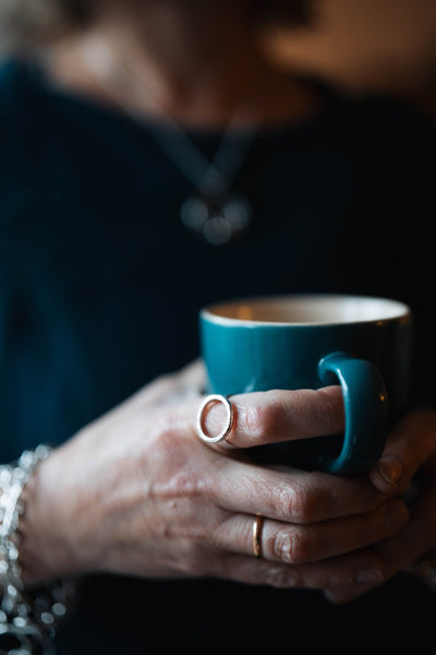Sterling Silver Halo Ring by LaVidaLoca Jewellery shown on hand holding mug