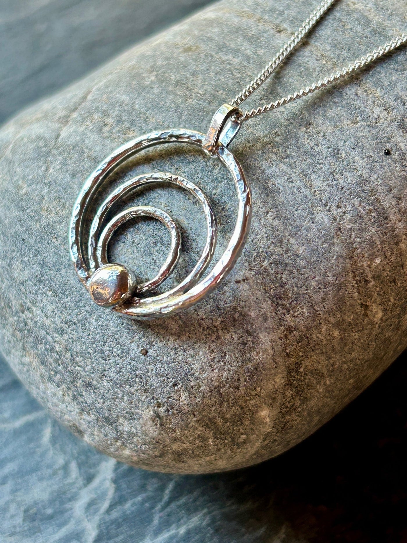 Sterling Silver Orbit Pendant by LaVidaLoca Jewellery shown on stone