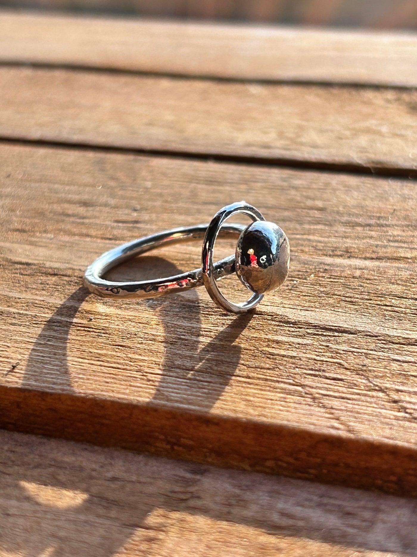 Sterling Silver Orbit Ring by LaVidaLoca Jewellery shown on a wooden background