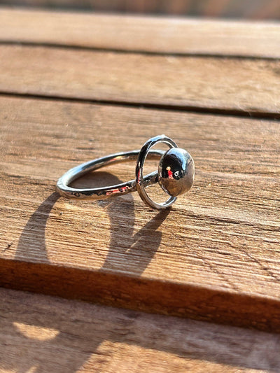 Sterling Silver Orbit Ring by LaVidaLoca Jewellery shown on a wooden background