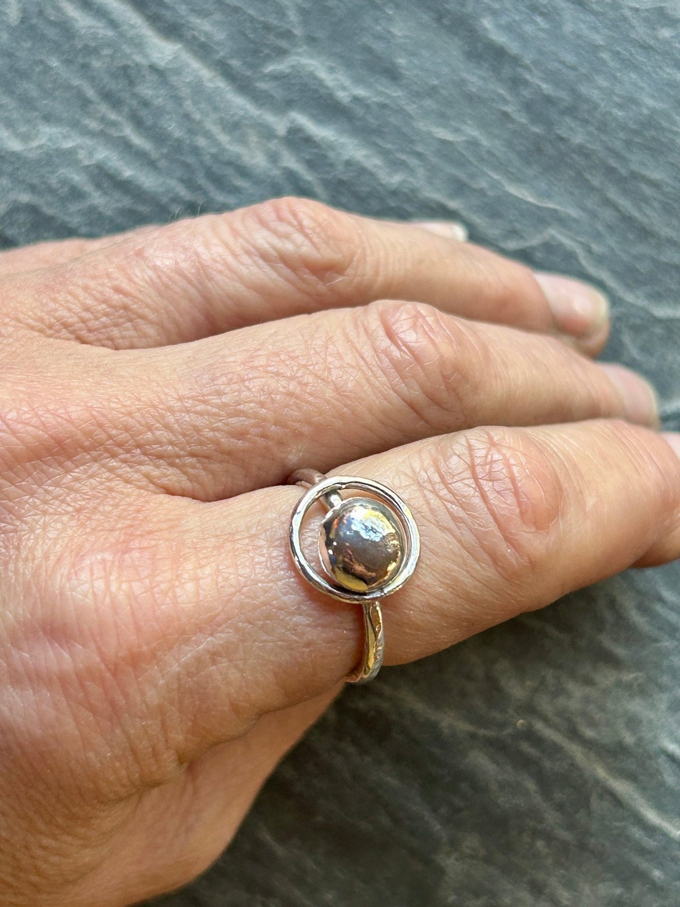 Sterling Silver Orbit Ring by LaVidaLoca Jewellery shown being worn on a slate background