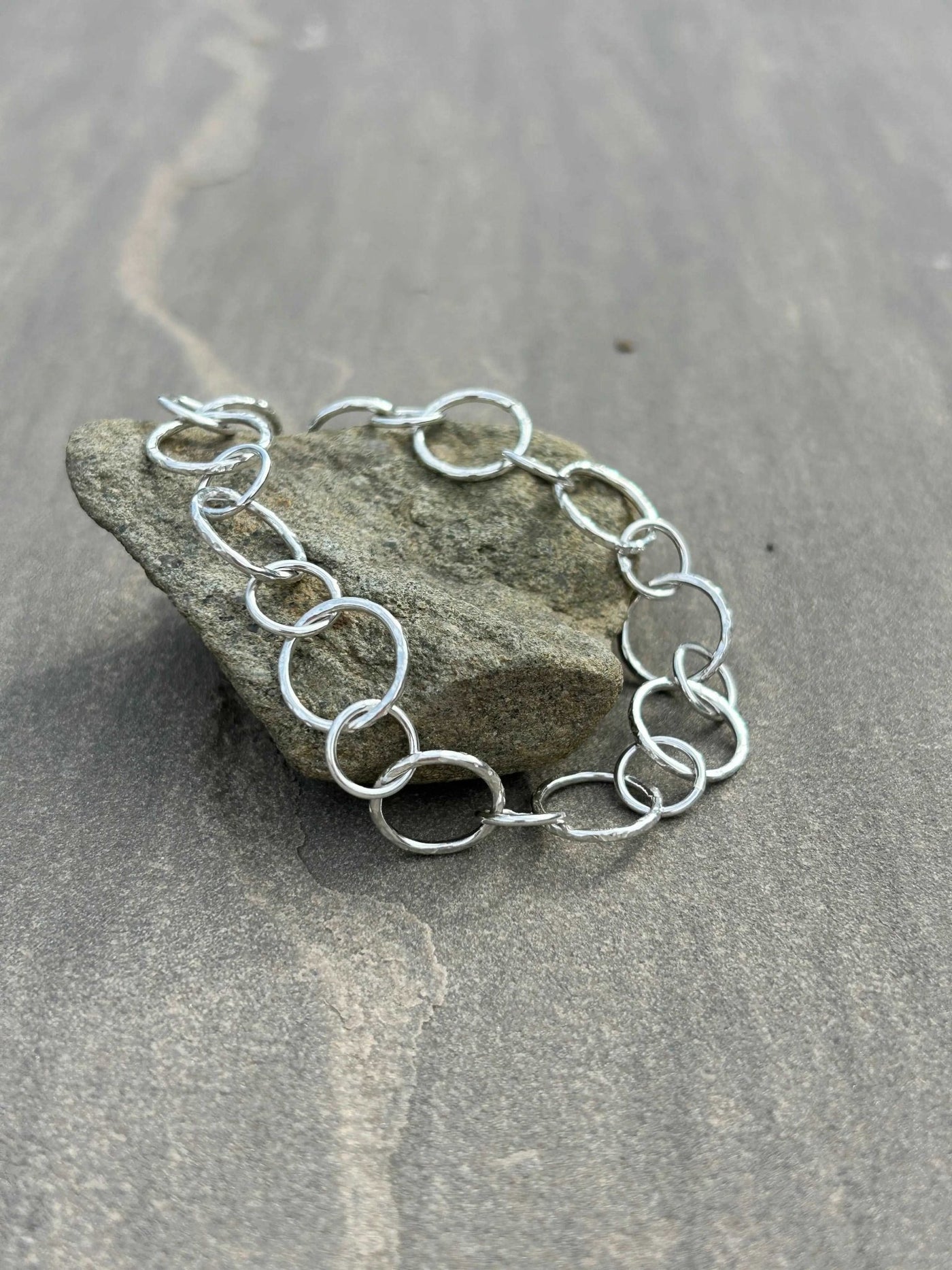 Sterling Silver handmade chain bracelet shown on a stone