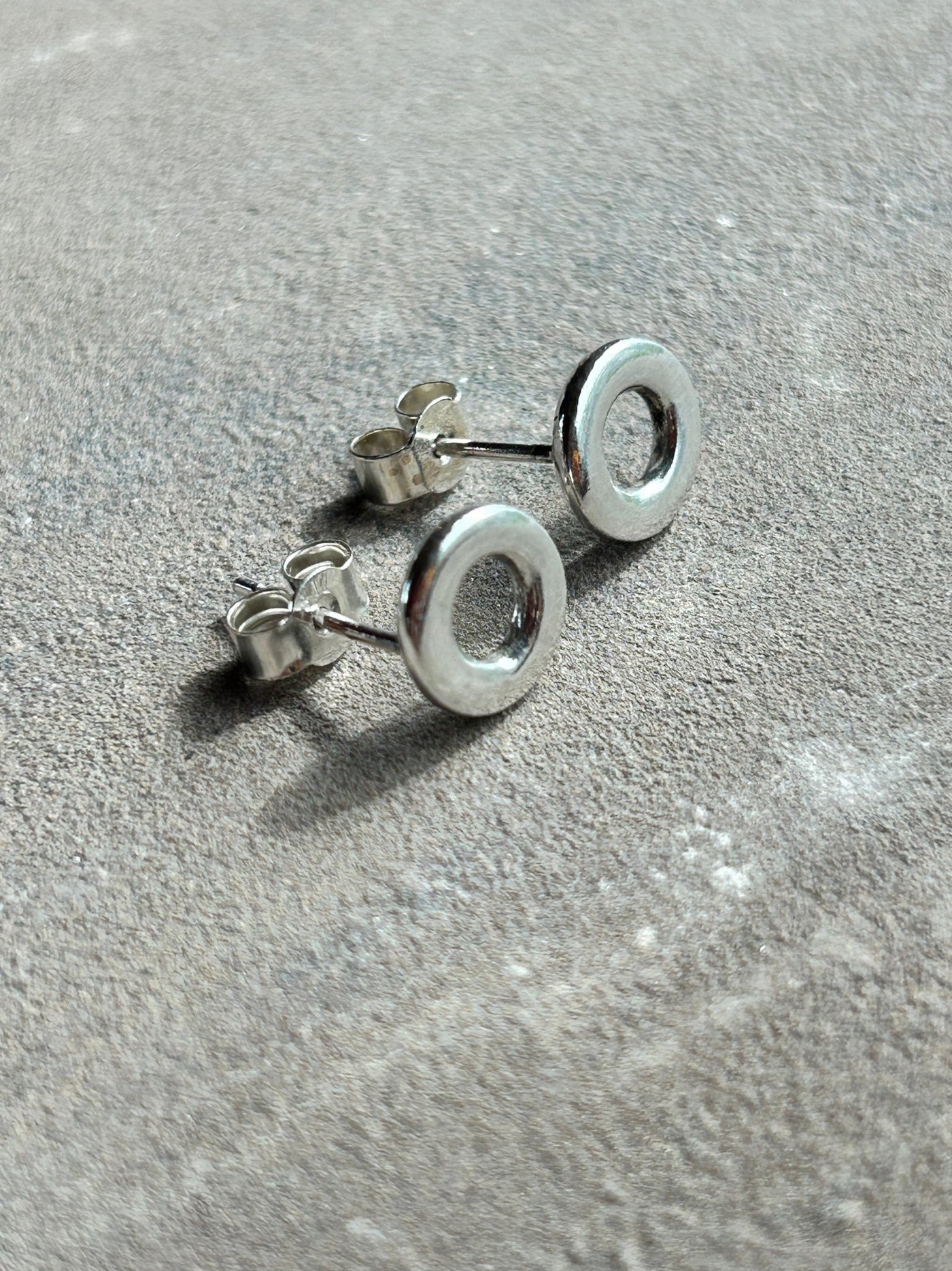 Sterling Silver Circle stud earrings by LaVidaLoca Jewellery shown on a slate side view