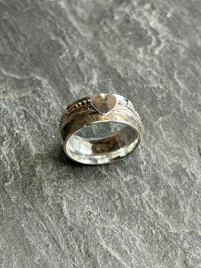 Sterling Silver Heart Spinner ring with three spinning bands on a slate background