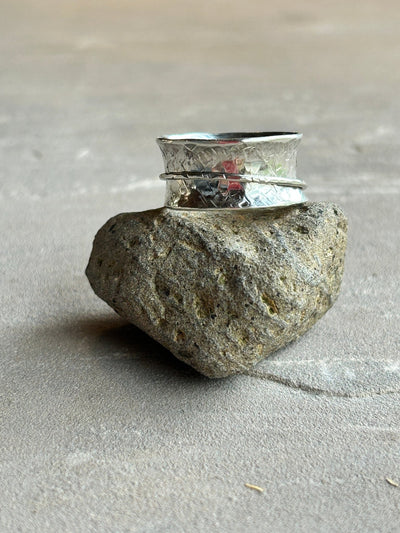 Sterling silver spinner ring with one silver outer spinning band shown on a stone