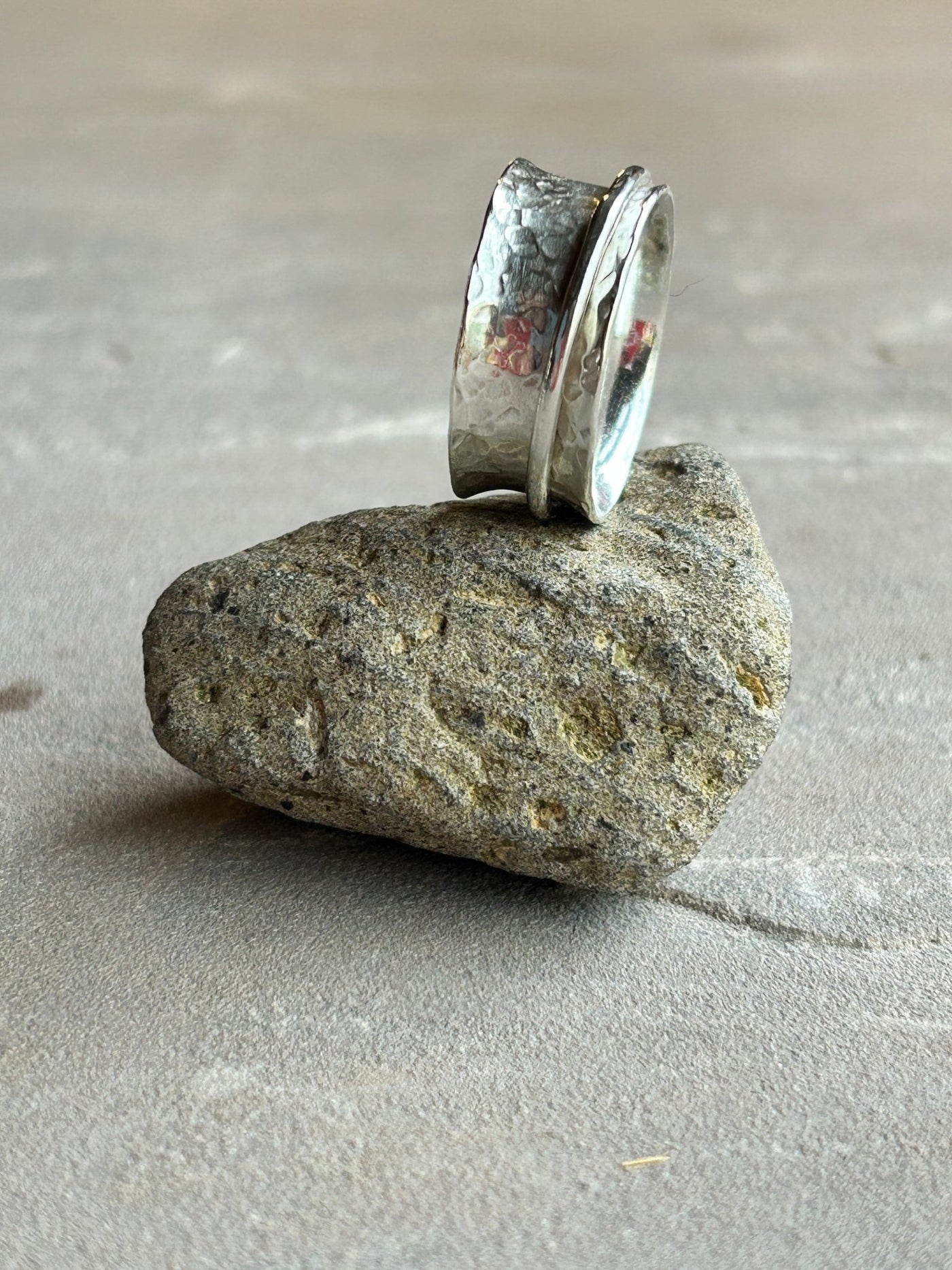 Sterling Silver Spinner ring with one wide silver spinner placed on a stone background - by LaVidaLoca Jewellery