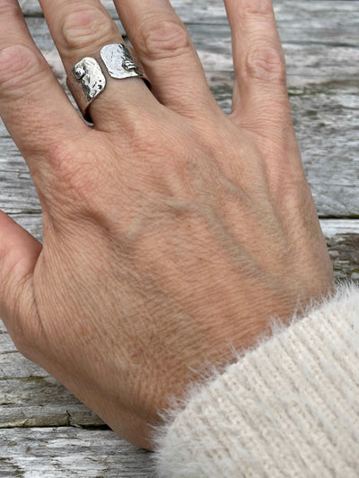 handmade Hammered Rivet Silver Ring with adjustable open-front design. shown on a hand